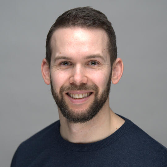 A headshot picture of Evan Poncelet, evaluation consultant.